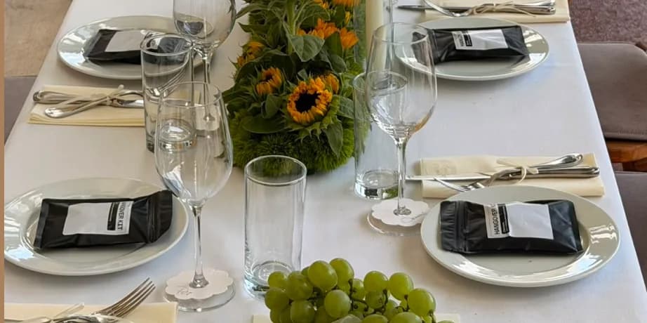 Laid table with sunflowers, wine glasses and folded napkins